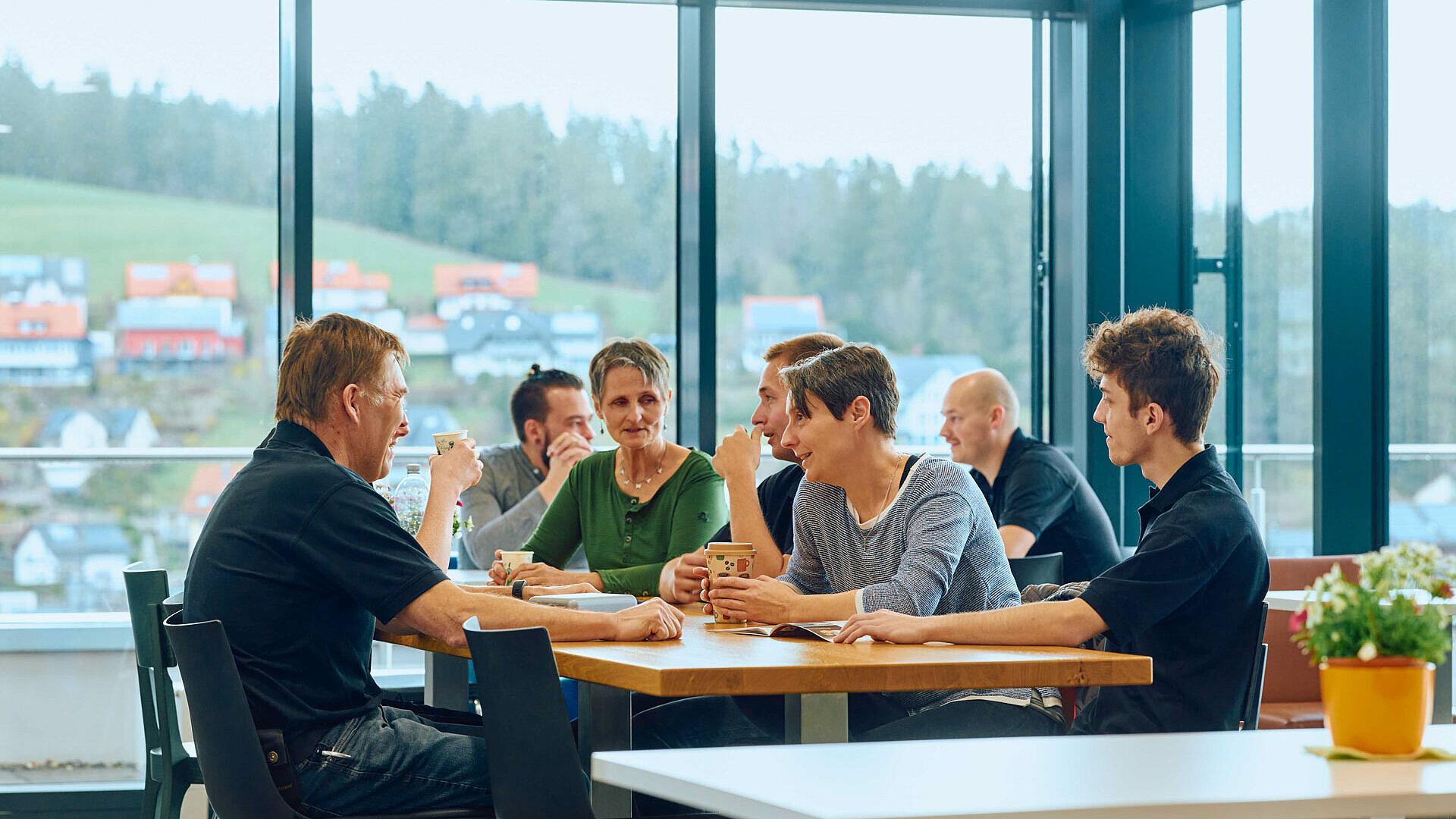 A group of people sitting at a table waiting to be served.
